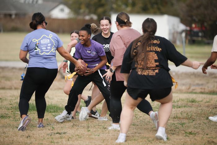 A powderpuff runner smiles as defenders close in