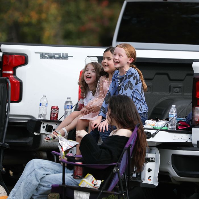 Girls laugh on a truck tailgate